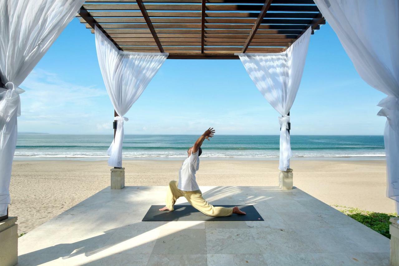 The Seminyak Beach Resort & Spa Eksteriør billede A man practicing yoga at the beach